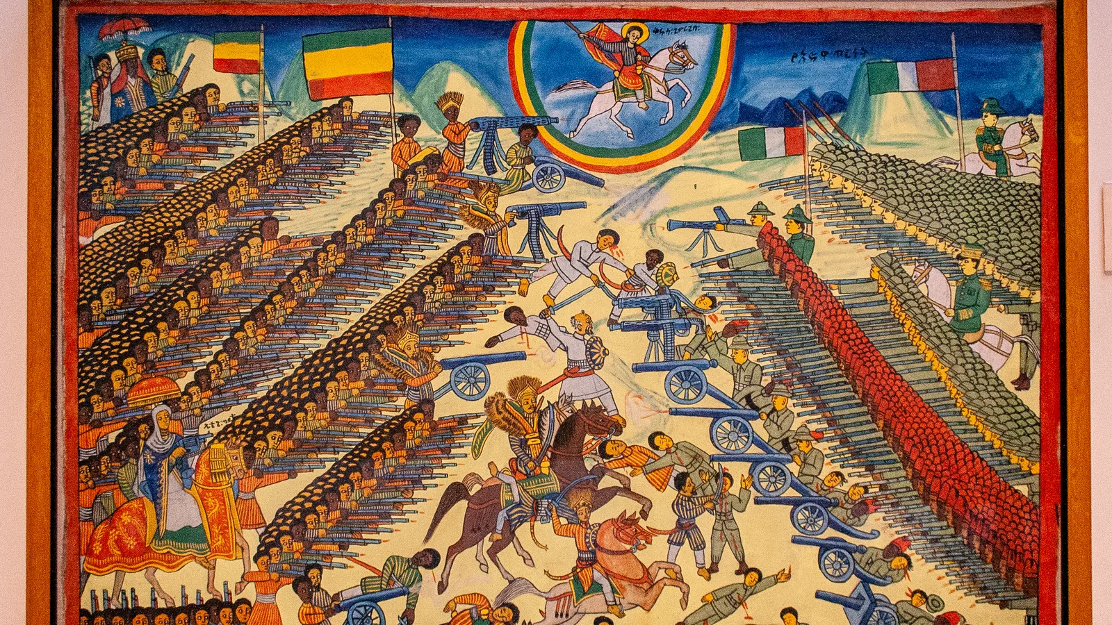 an Ethiopian painting in flat bright colors of ranks of soldiers, horsemen and cannon, with a mounted saint in a rainbow above them