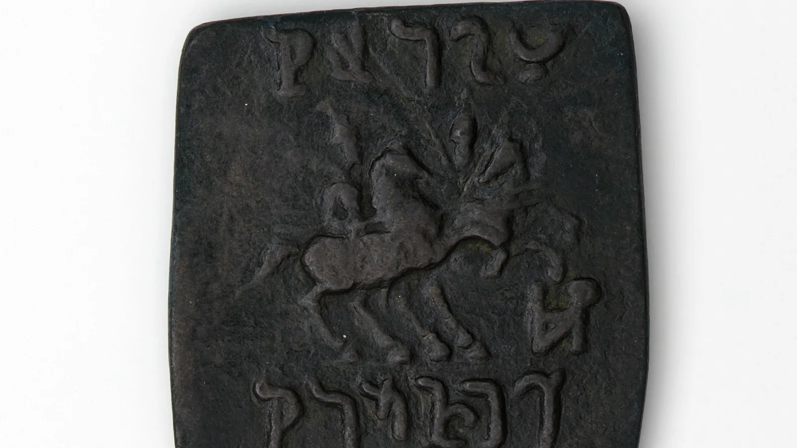A worn bronze coin stamped with a helmeted profile head