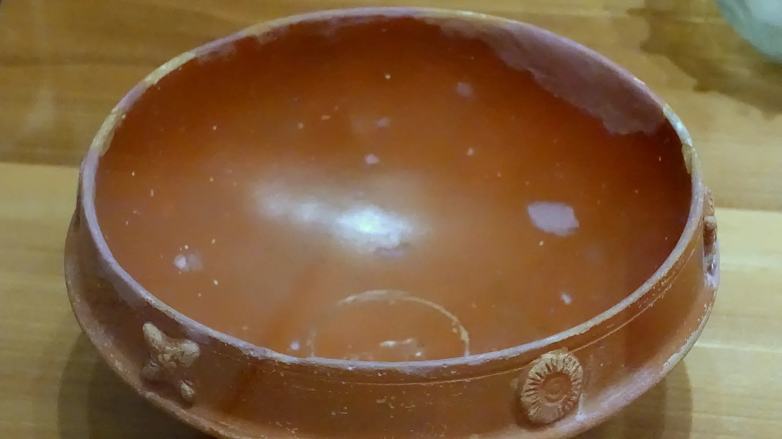 A red-glossed terracotta bowl with a wide rim, the type of Arretine ware found in sherds at Arikamedu