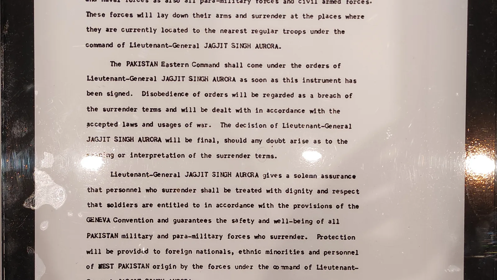 typed paragraphs of a surrender document displayed under glass, naming Lieutenant-General Jagjit Singh Aurora