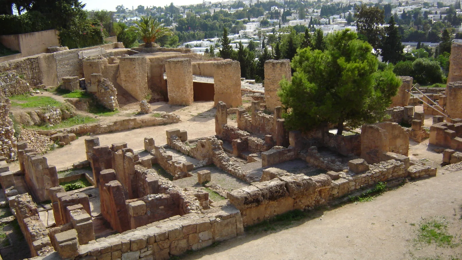 Stone ruin walls of the Punic quarter on Byrsa hill with the sea and modern city in the distance