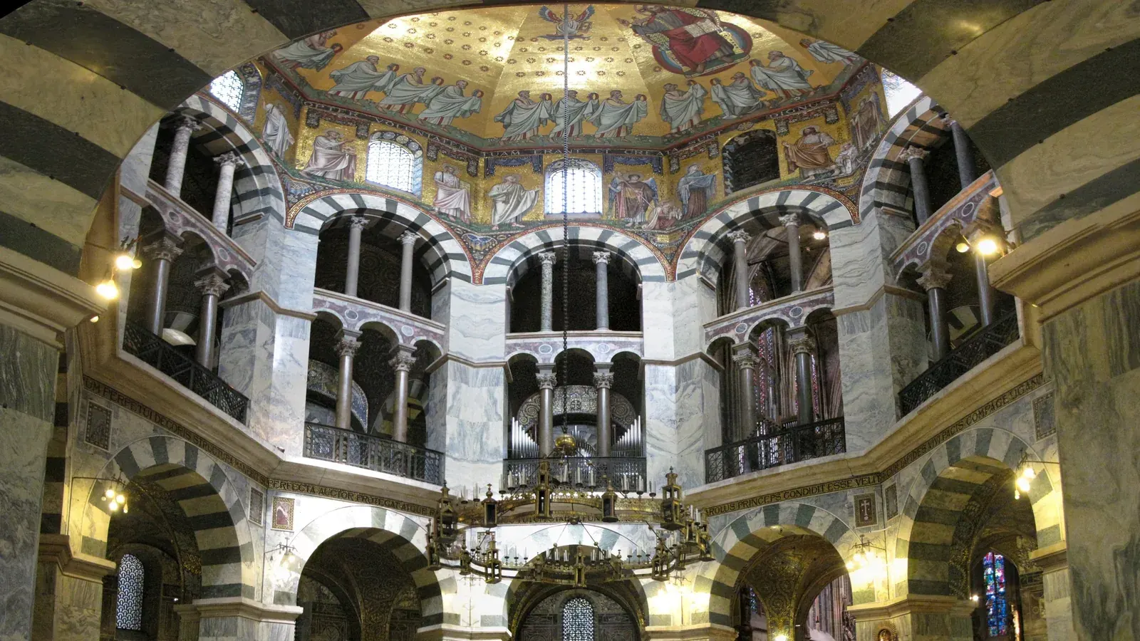 the octagonal interior of a Carolingian chapel with striped arches and a chandelier