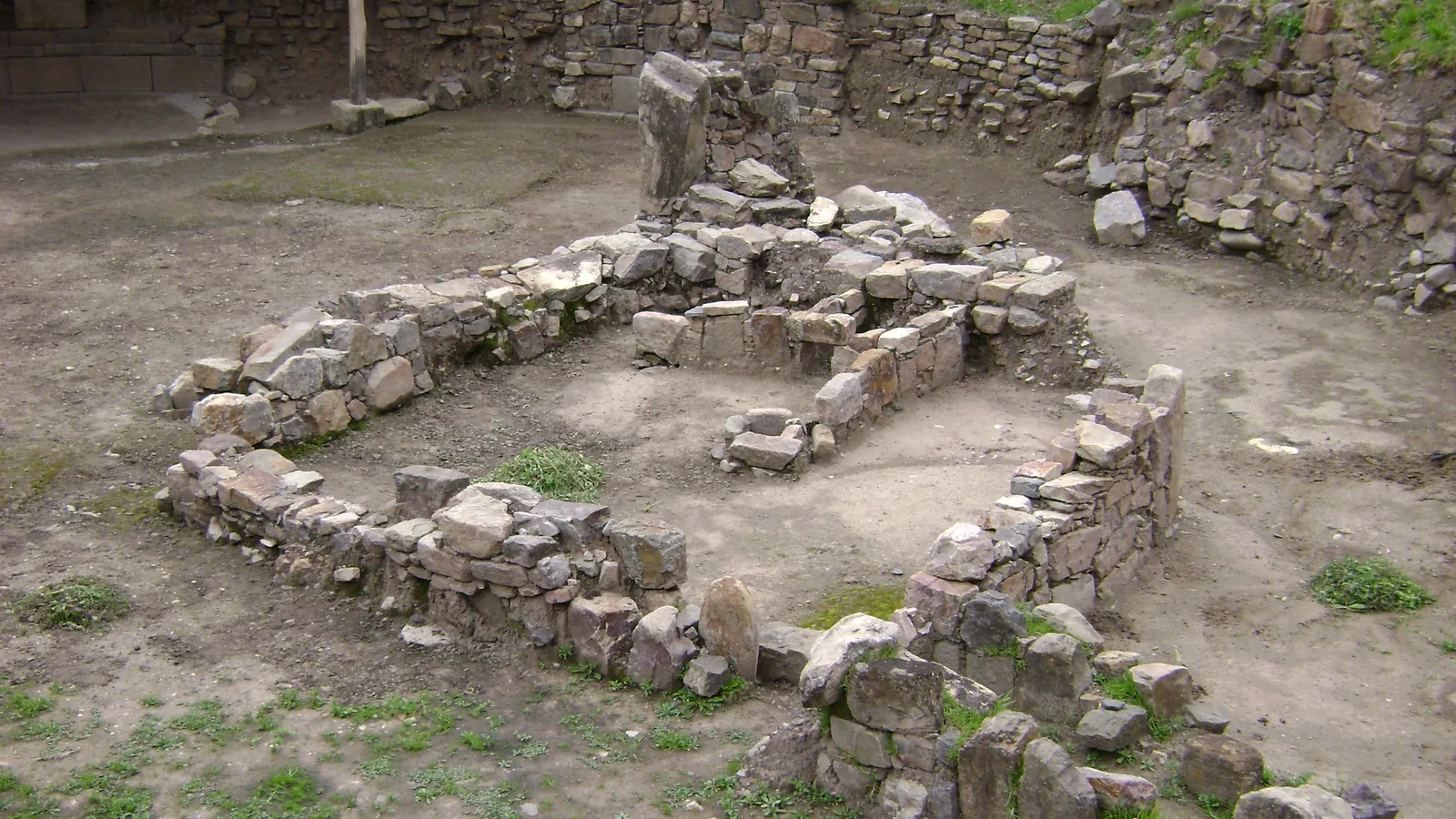 a sunken circular plaza of fitted stone with a low stone wall and stepped terraces behind it