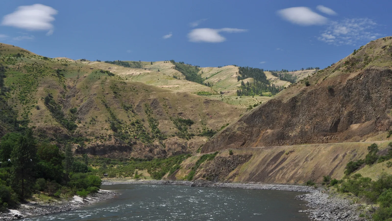 River bend below steep grassy canyon walls, no buildings or people visible