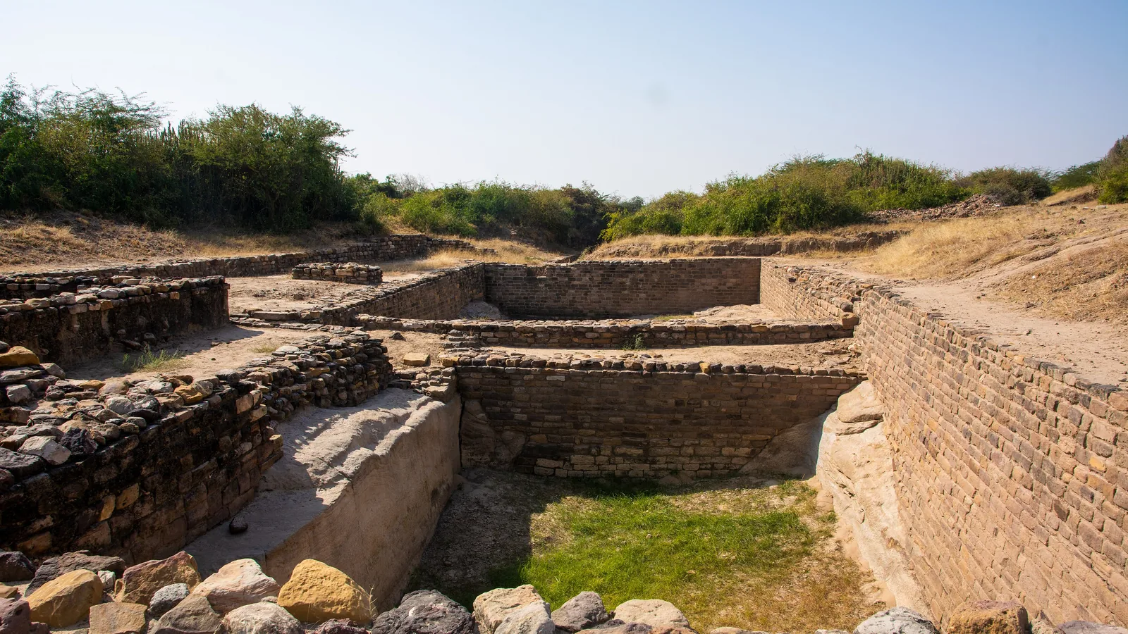 Stone wall ruins and open ground at the Dholavira archaeological site