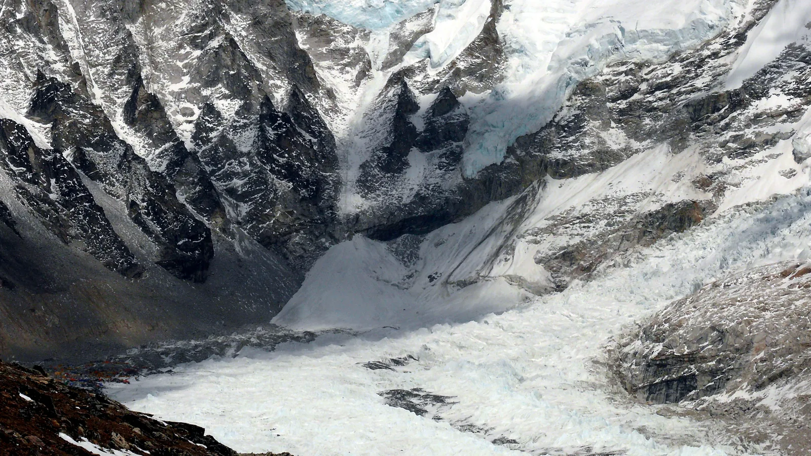 Broken, jumbled ice blocks of a glacier icefall descending a steep mountain valley
