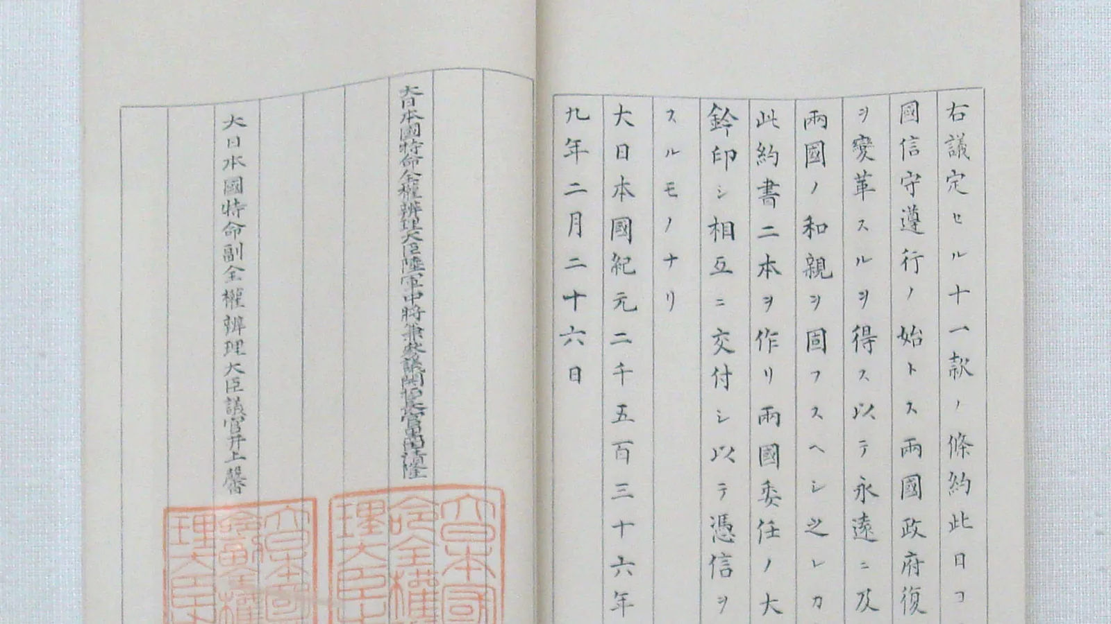an open bound document with columns of brush-written Japanese and Chinese characters and two red seal impressions