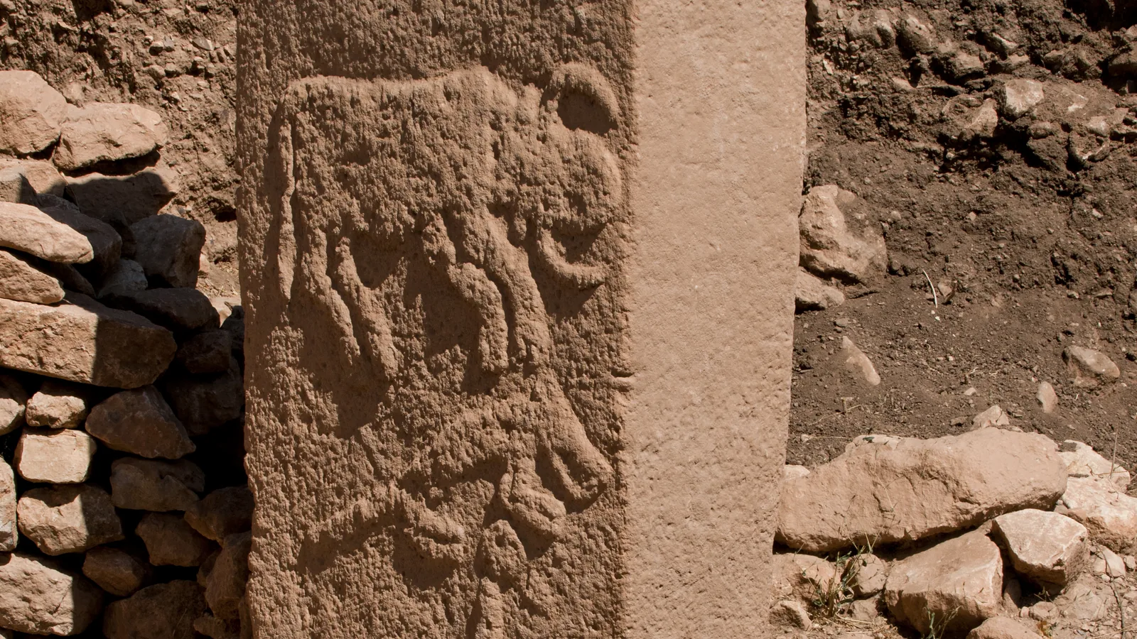a T-shaped limestone pillar carved in low relief with a fox, a bull and a crane