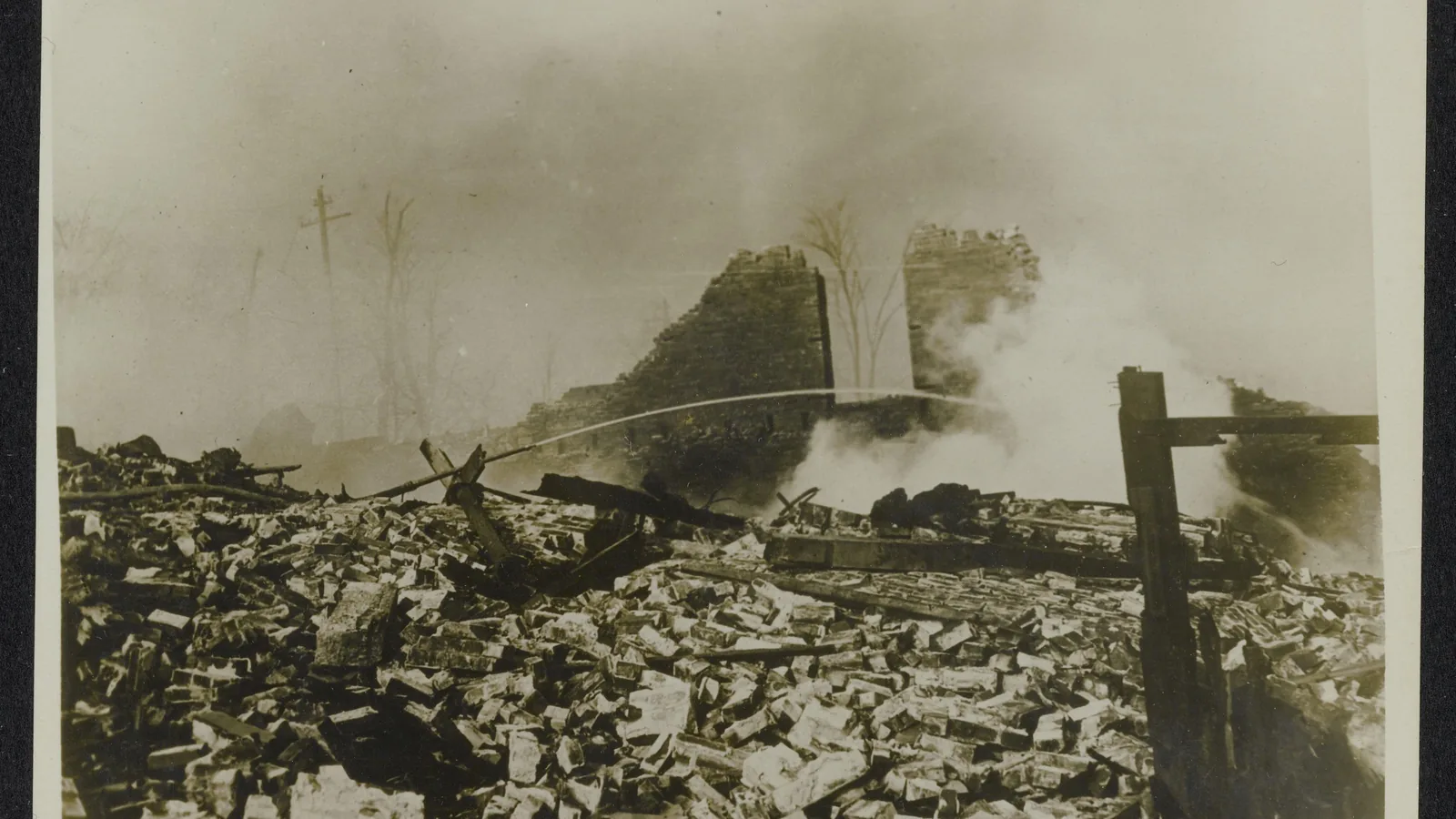 Wide view of a leveled harbor district with scattered rubble and debris