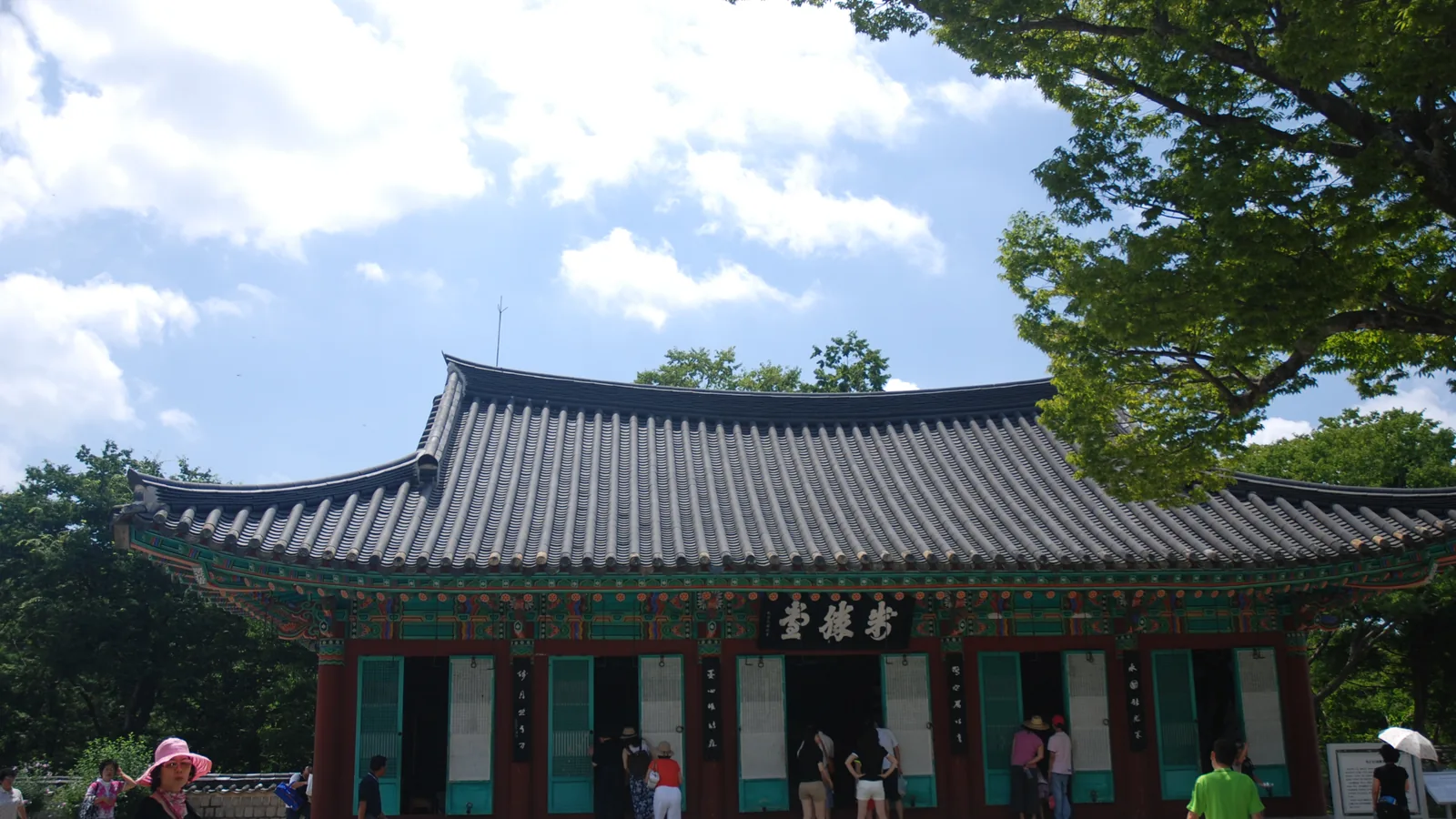 Traditional Korean shrine building with tiled roof among trees on Hansan Island