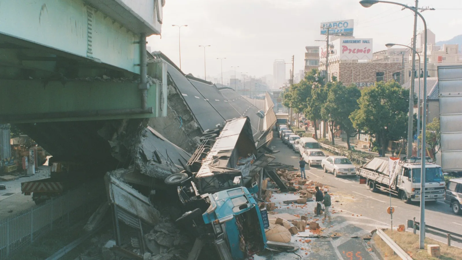 Elevated expressway toppled onto its side along a city street after an earthquake