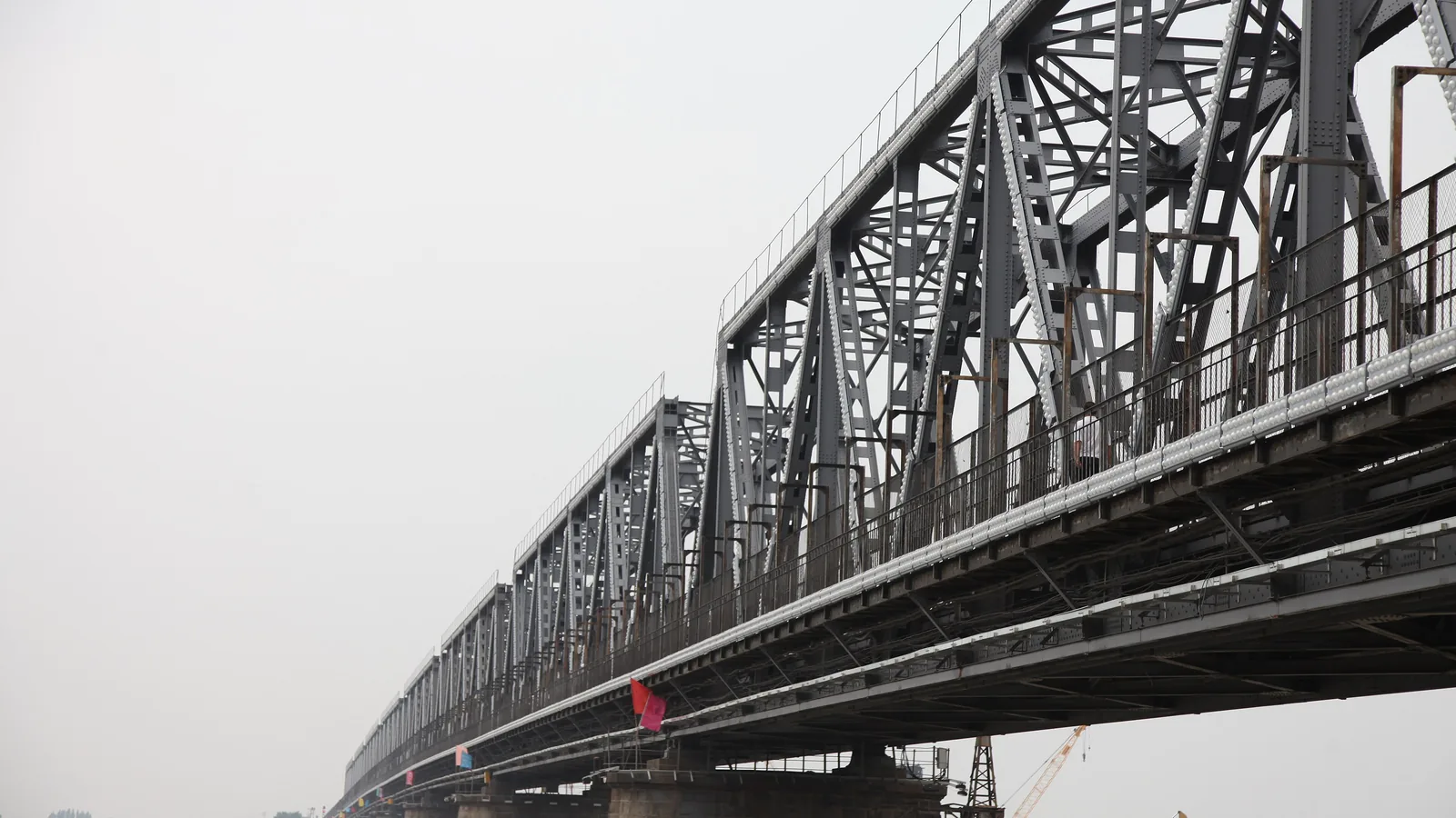 An old steel railway bridge crossing the wide Songhua River at Harbin
