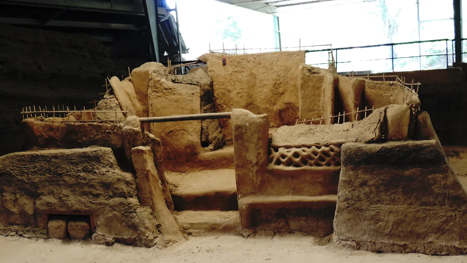 Excavated adobe steps and walls of a Maya structure under a protective roof shelter