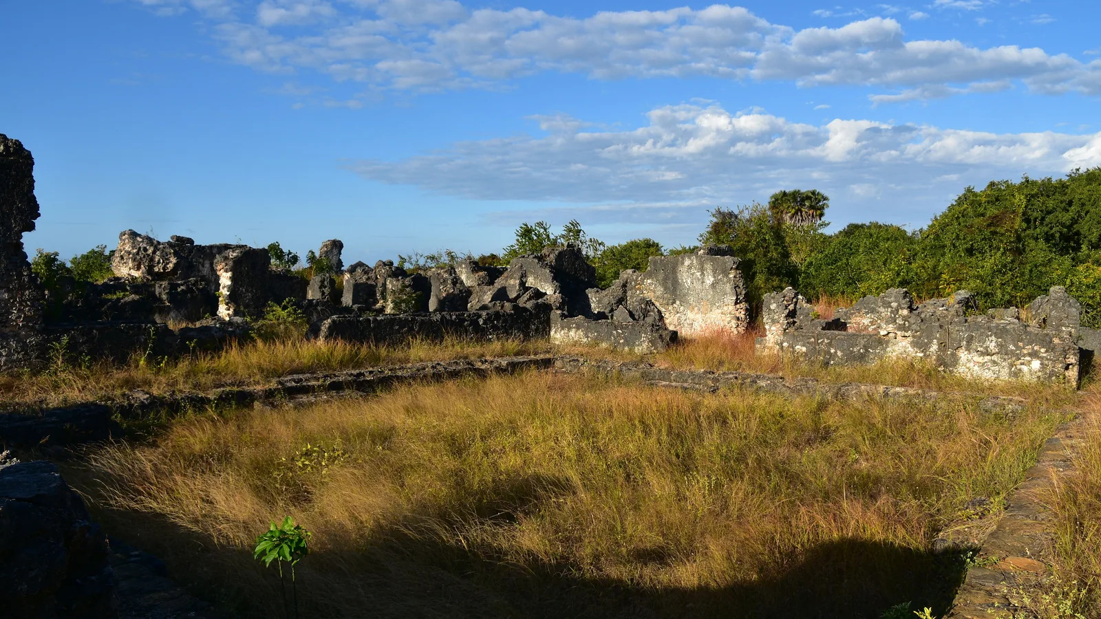 Coral stone ruin walls of the Husuni Kubwa palace at Kilwa Kisiwani under a blue sky