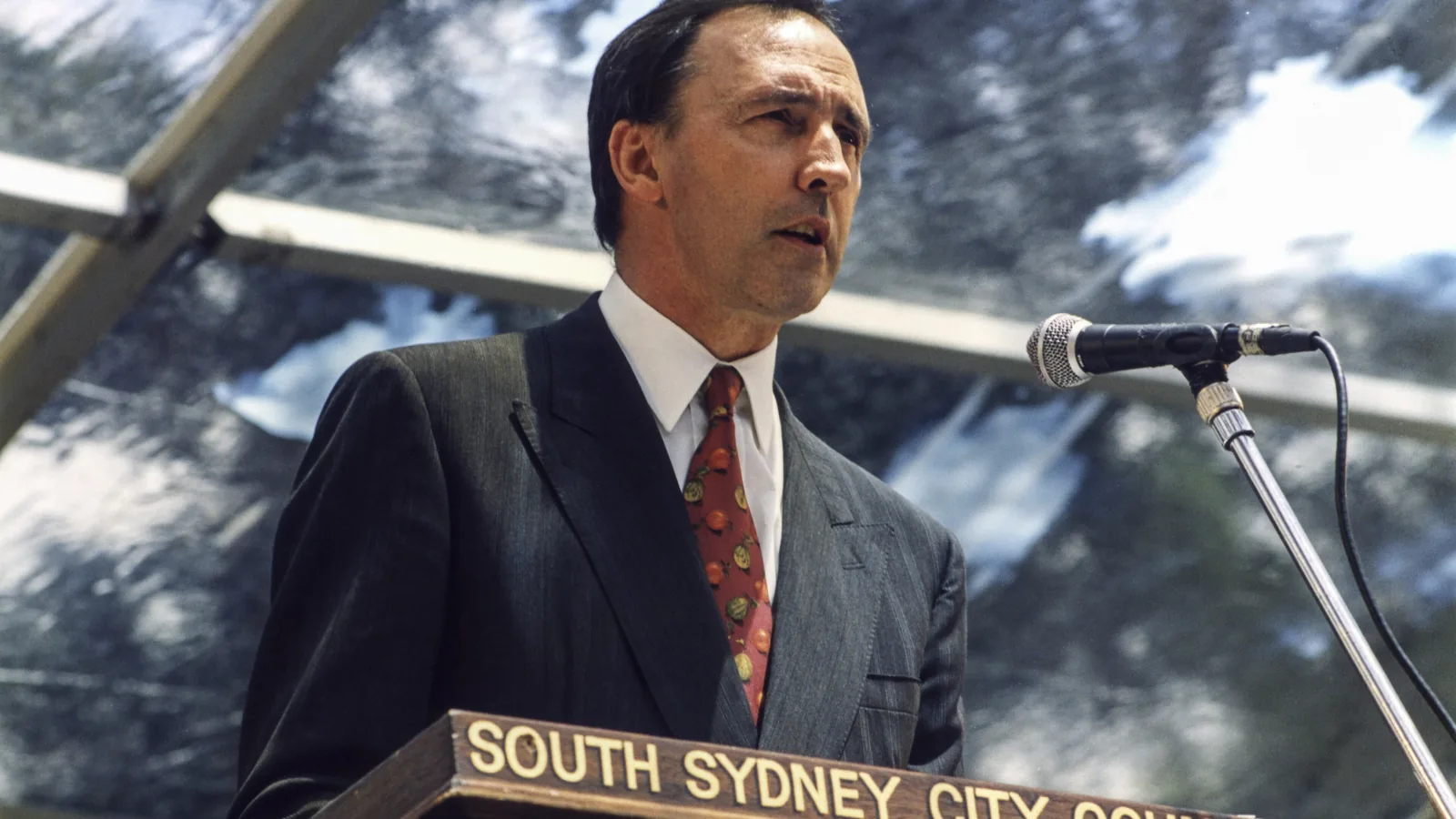 Paul Keating speaking at an outdoor lectern before a crowd at Redfern Park