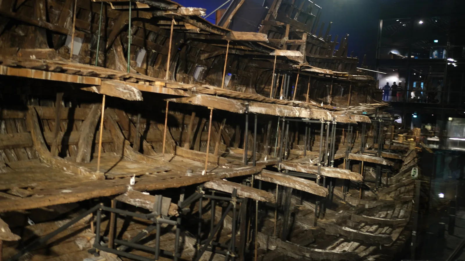 Interior view of the preserved timber hull of the Mary Rose, tiered and supported by metal props, in a museum