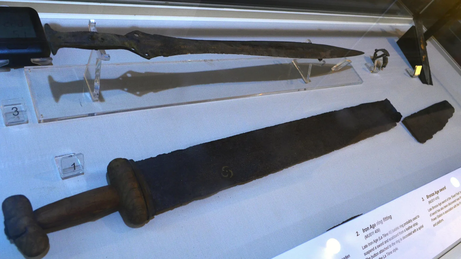 Several bronze and iron age swords displayed together in a museum case