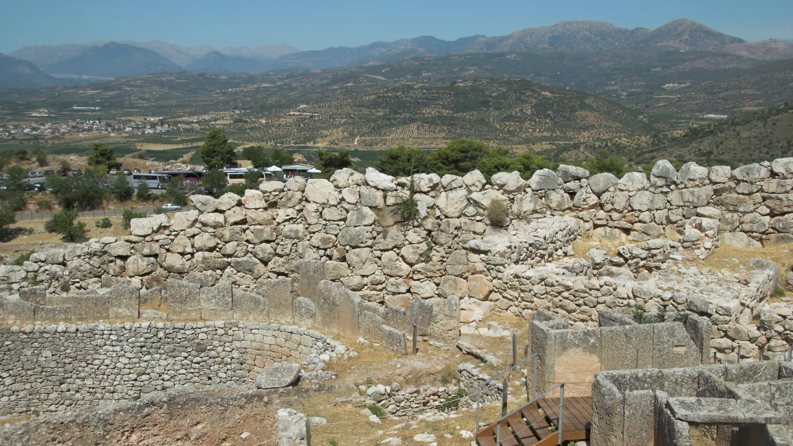 Low stone ring wall of an ancient grave circle with hills and a valley in the background