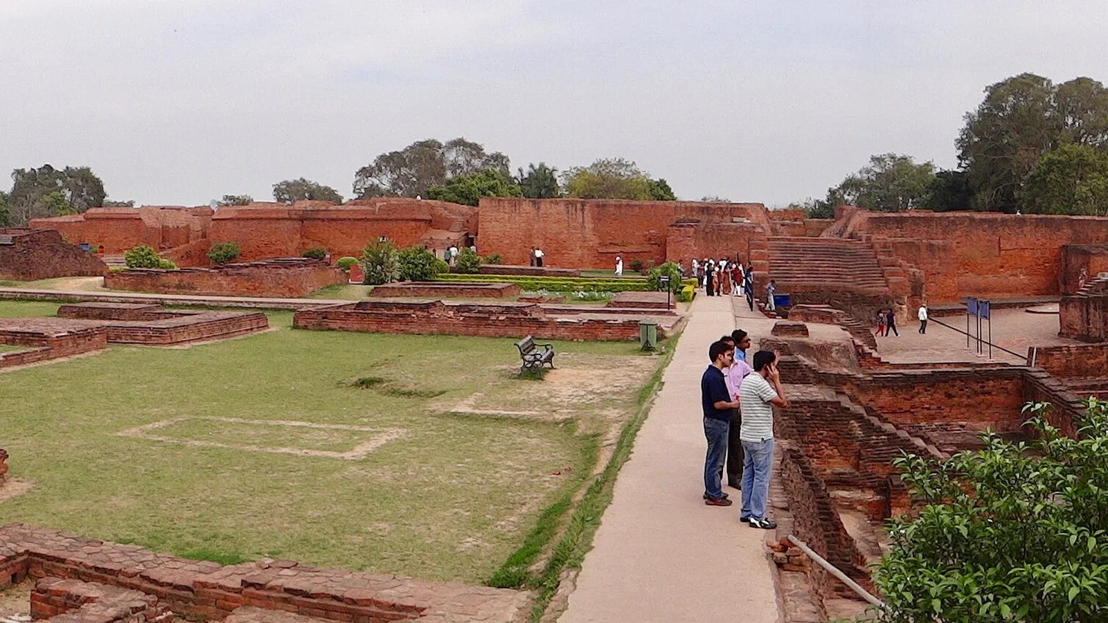 Wide view of excavated brick monastery ruins and courtyards at Nalanda under an open sky
