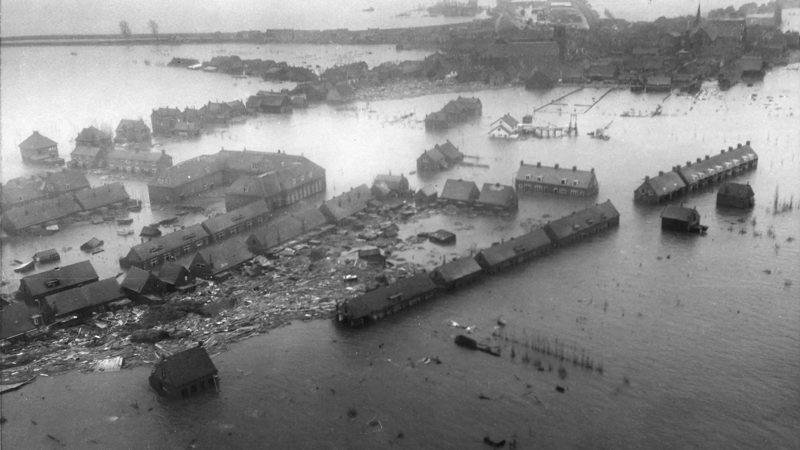 Aerial view of a flooded Dutch town with damaged buildings surrounded by water