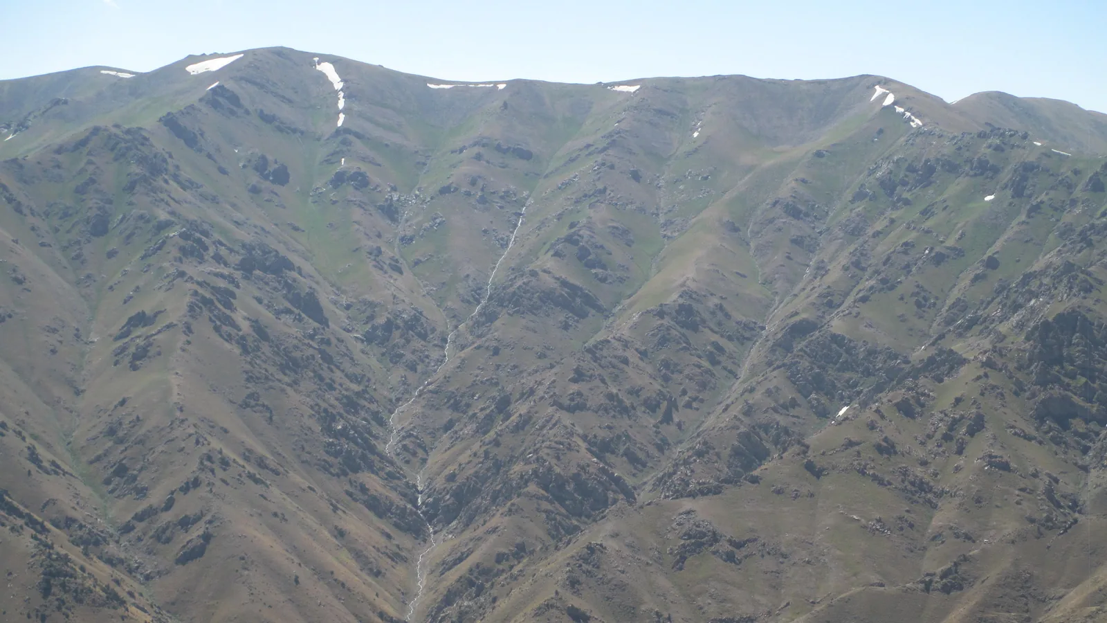 Green mountain ridge with rocky peaks in the western Tian Shan