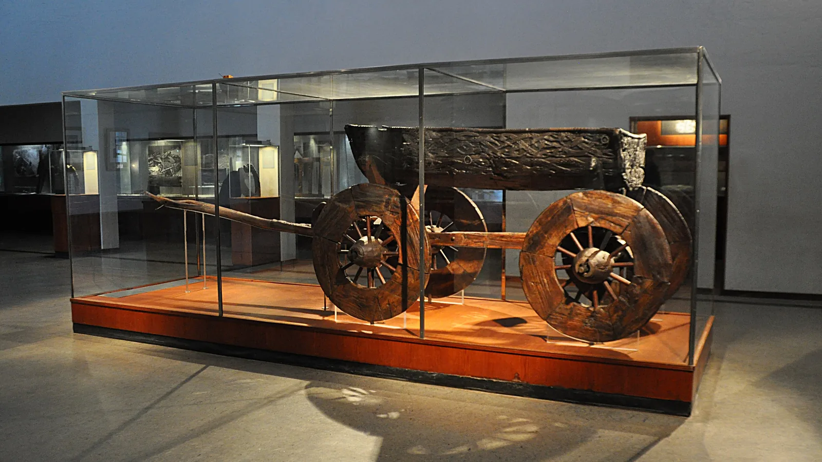 Carved wooden four-wheeled cart from the Oseberg ship burial, on museum display