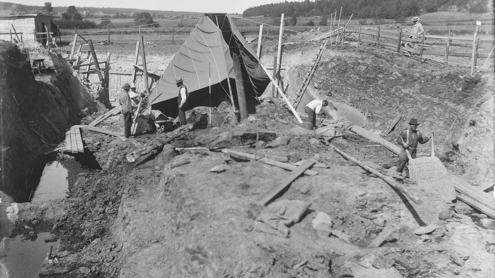 Archaeological excavation of a large wooden Viking ship half-buried in earth
