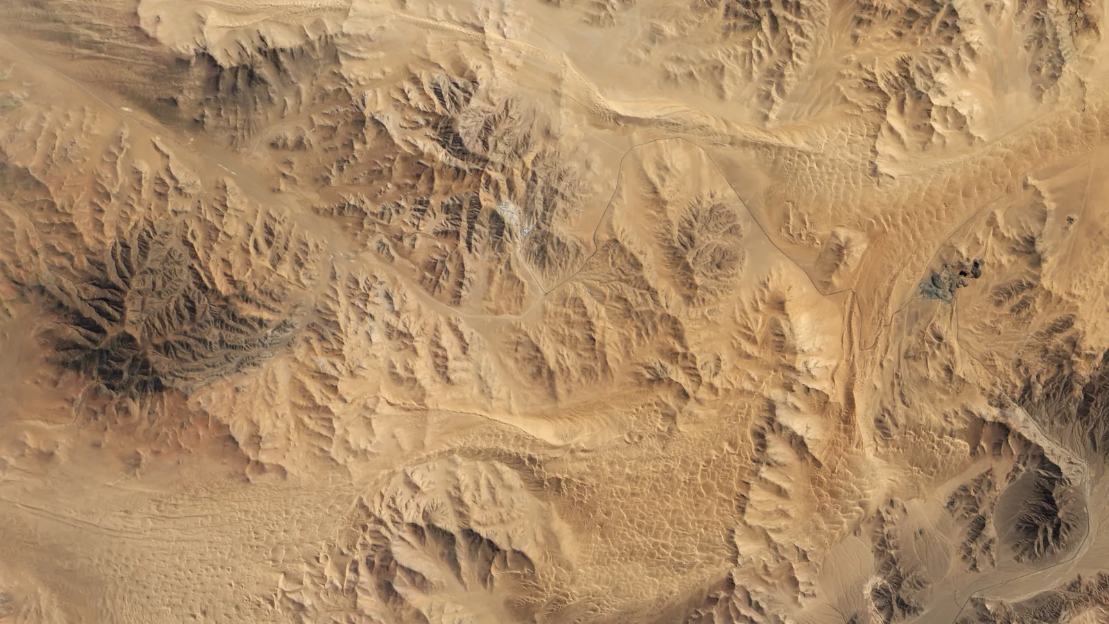 Natural-color satellite image of a mine site amid desert terrain