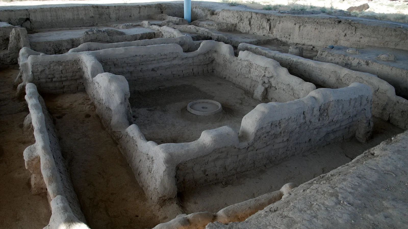 Excavated mud-brick walls under a protective roof at Sarazm