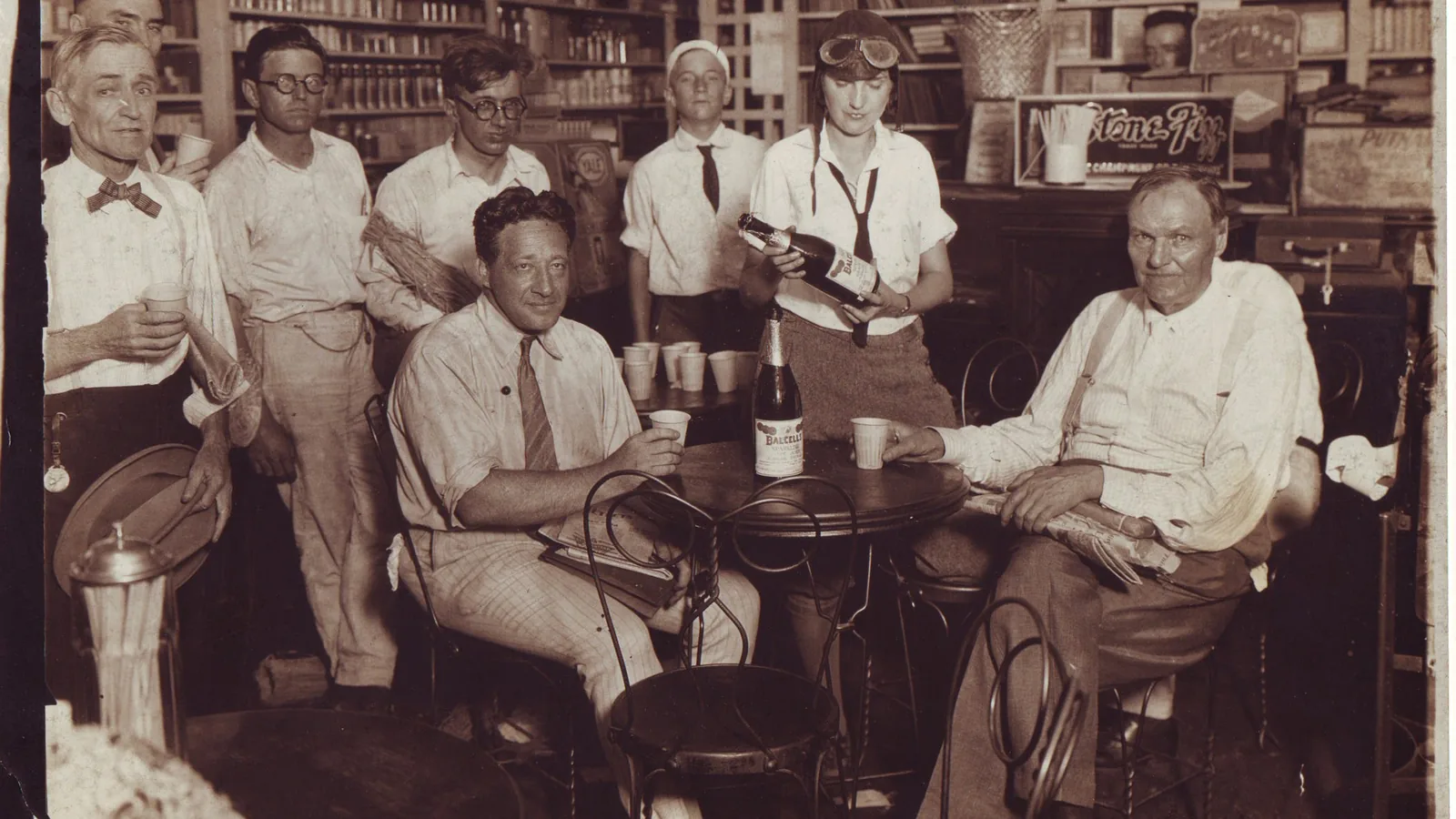 a black and white photograph of three men in suits standing inside a drugstore in Dayton, Tennessee