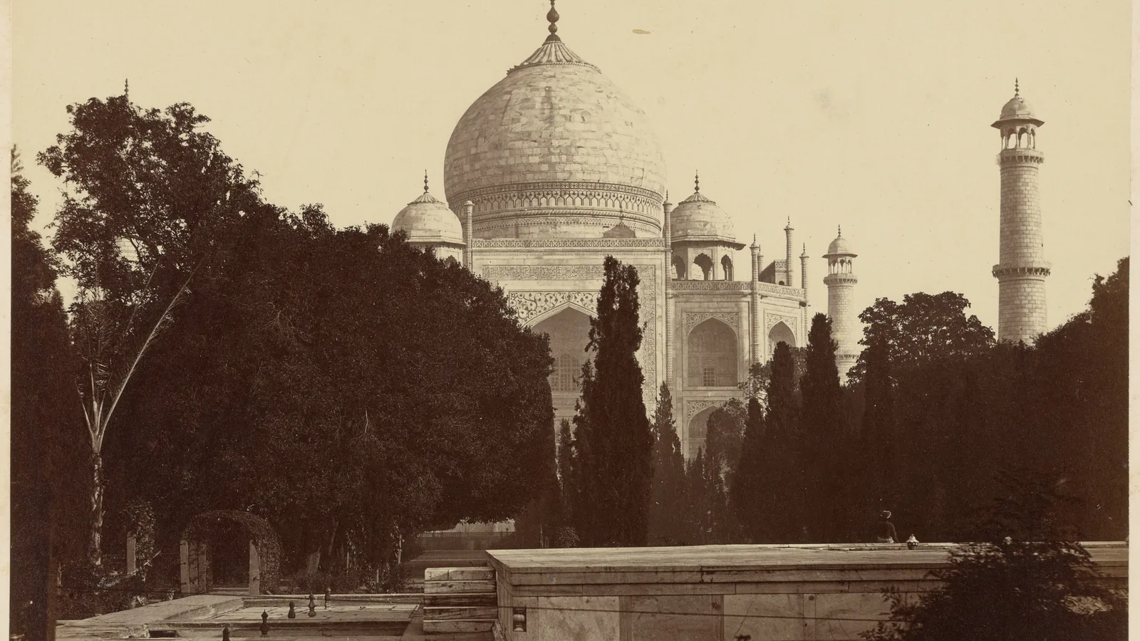 Sepia photograph of the Taj Mahal seen down the garden's central water channel, cypresses on either side