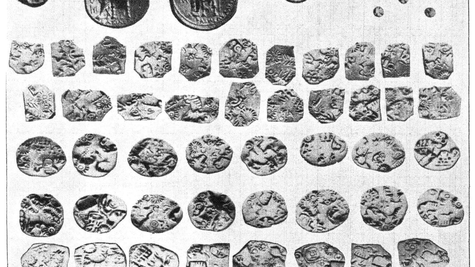 A group of ancient coins of differing sizes laid out on a surface