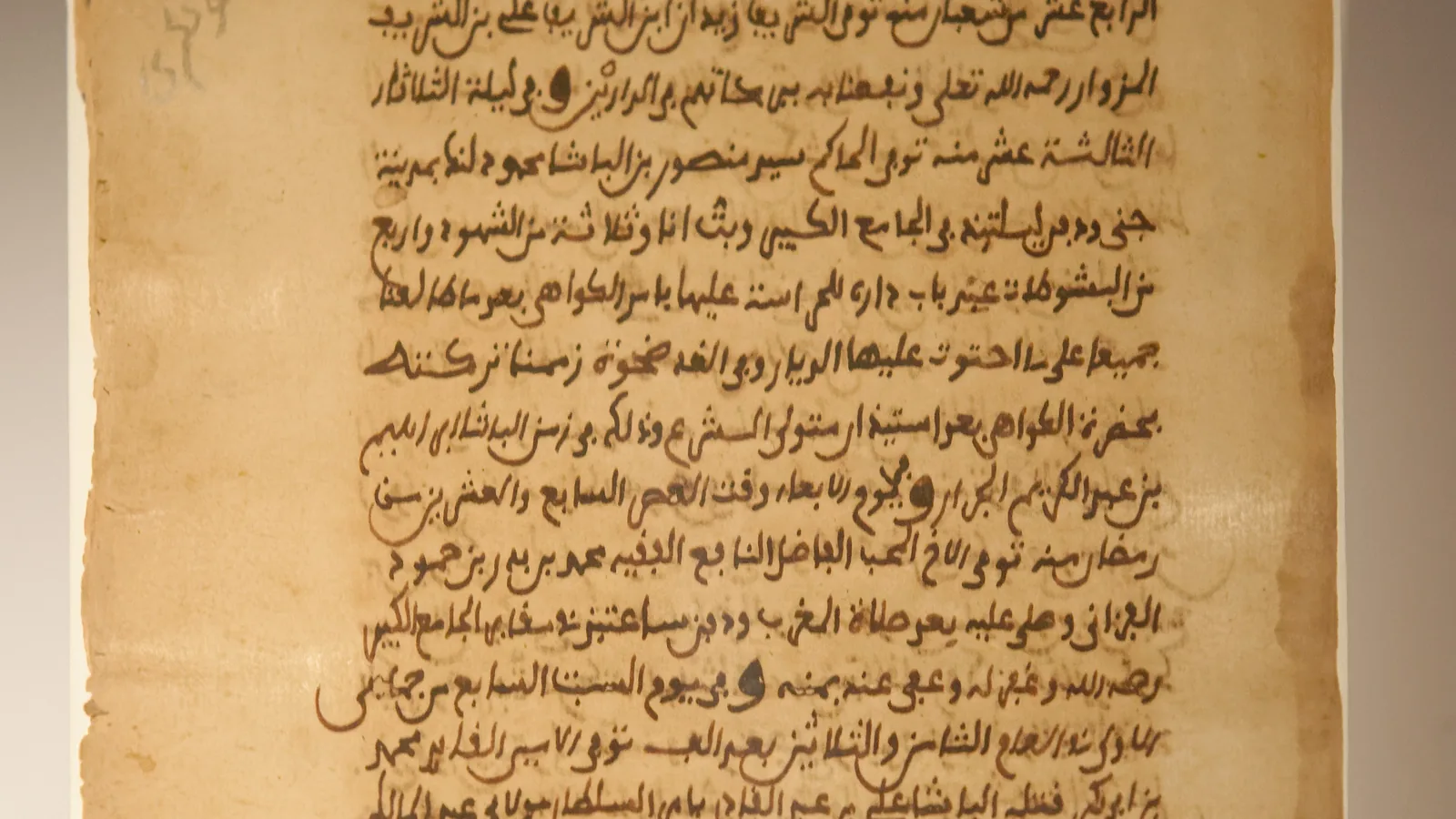 A manuscript page of Arabic script in brown ink with red headings on aged paper