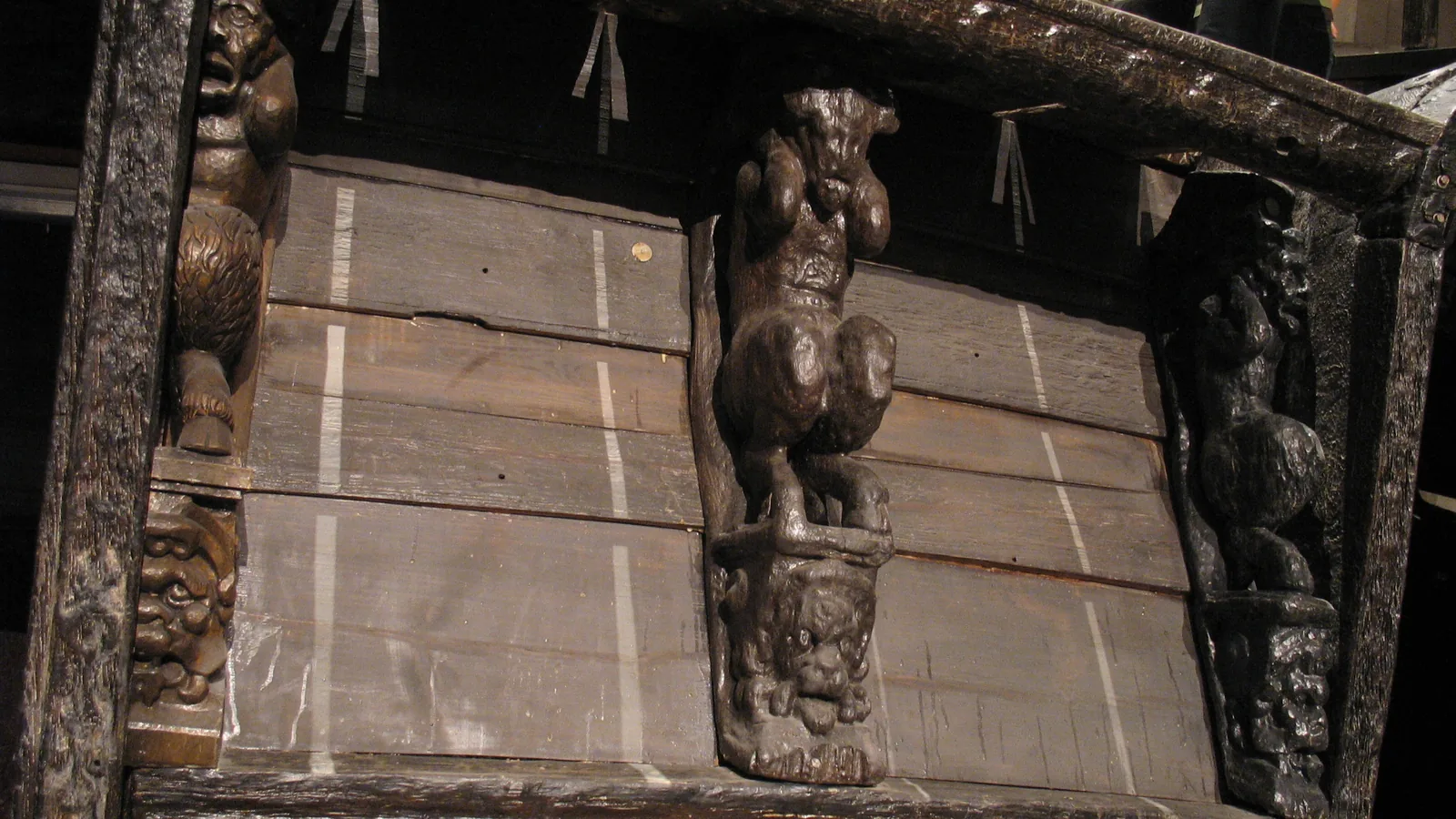 Carved wooden gargoyle figures on the ship's sterncastle deck